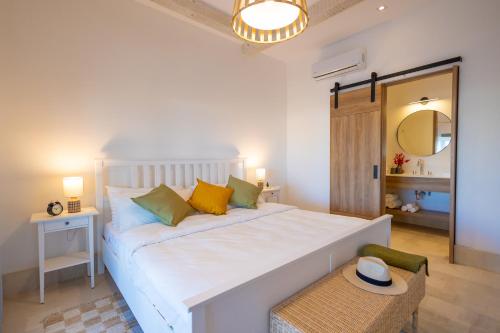 1 dormitorio con cama blanca, mesa y espejo en Vinícola Parvada Villa 8 servicio tipo hotel, en Parras de la Fuente