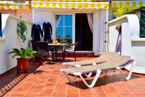 a patio with a table and chairs on a balcony at Komfortable Ferienwohnung erste Strandreihe Playa Burriana in Nerja