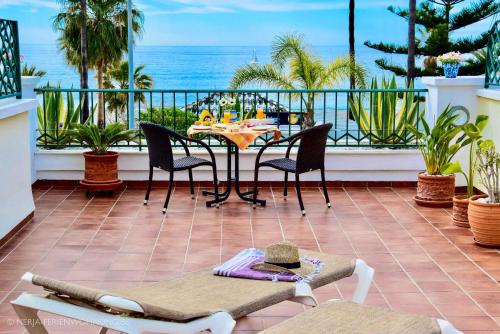 a patio with a table and chairs and the ocean at Komfortable Ferienwohnung erste Strandreihe Playa Burriana in Nerja