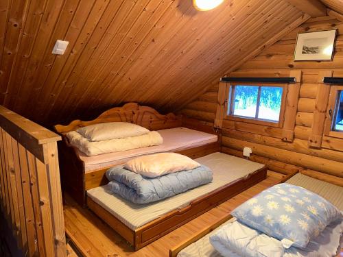 1 Schlafzimmer mit 2 Betten in einer Holzhütte in der Unterkunft Koslig tømmerhytte in Kilpisjärvi