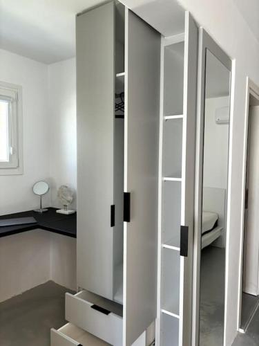 a white cabinet with a mirror in a room at Minimal Grey Apartment Pool-front in Paros in Parikia