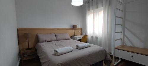een slaapkamer met een bed met twee handdoeken erop bij Apartamento Santander zona Tetuán Puertochico in Santander