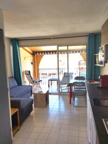 Il comprend un salon avec un canapé et une cuisine avec un balcon. dans l'établissement Appartement Vias-Plage, à Vias