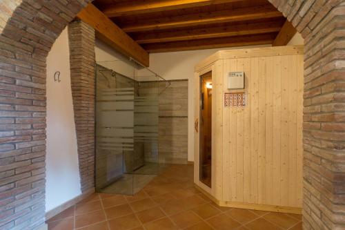 a walk in shower in a room with a brick wall at Agriturismo Al Tralcio in Valeggio sul Mincio