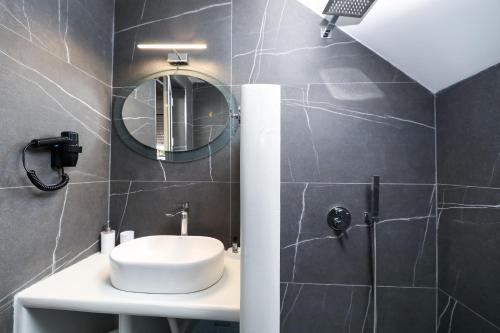 a bathroom with a sink and a mirror and a shower at Guest House Narta in Vlorë