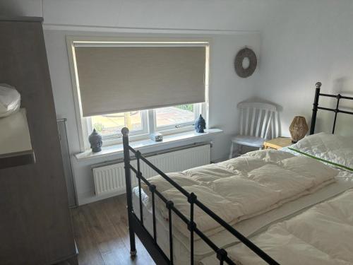 1 dormitorio con cama y ventana con sombra en Vakantie huis Ermelo, en Ermelo