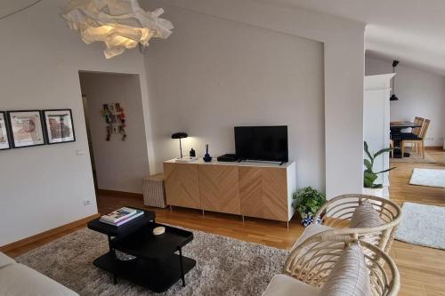 a living room with a couch and a tv at Boutique Rooftop with Ocean views in São Martinho do Porto