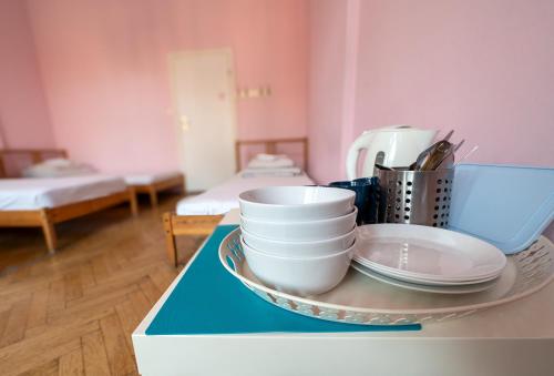 a tray with plates and cups on a counter at Trzy Kafki Private Rooms in Kraków