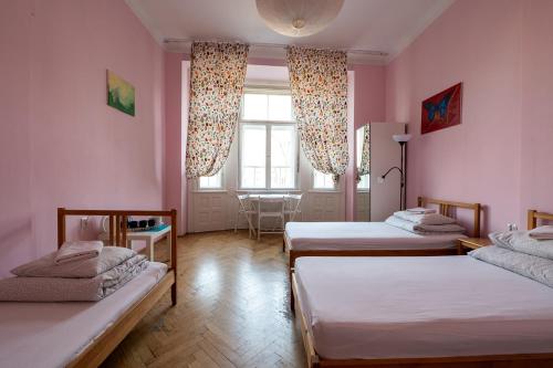 a room with two beds and a table and a window at Trzy Kafki Private Rooms in Kraków