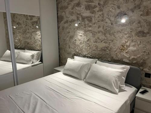 Schlafzimmer mit einem weißen Bett und einem Spiegel in der Unterkunft MORINGA - New unit for 2 AC close to beach in Antibes
