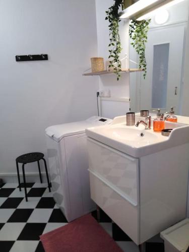 een witte badkamer met een wastafel en een spiegel bij Studio centre Bagnoles in Bagnoles de l'Orne