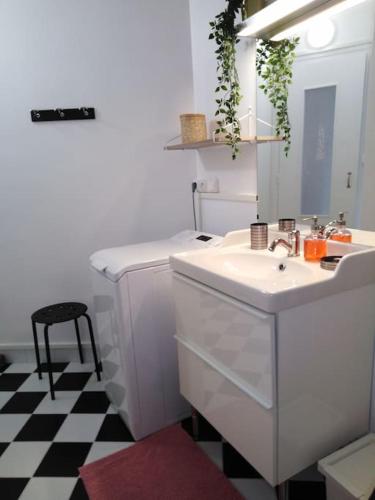 une salle de bain blanche avec un lavabo et un miroir dans l'établissement Studio centre Bagnoles, à Bagnoles-de-l'Orne