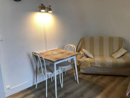 une pièce avec une table, des chaises et un canapé dans l'établissement Studio centre Bagnoles, à Bagnoles-de-l'Orne