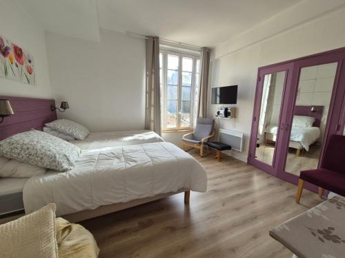 een slaapkamer met een groot bed en een kamer met een televisie bij Studio centre Bagnoles in Bagnoles de l'Orne