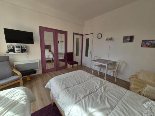 een slaapkamer met een bed, een bank en een tafel bij Studio centre Bagnoles in Bagnoles de l'Orne