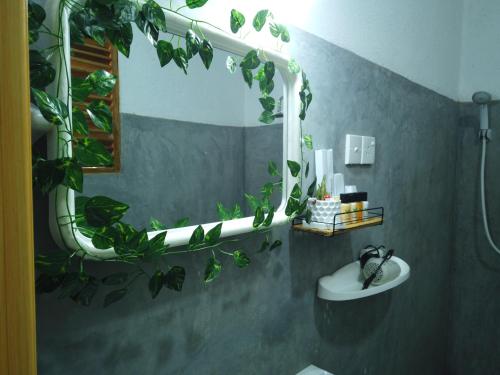 a bathroom with a sink and a mirror with plants at Green View Safari Resort in Udawalawe