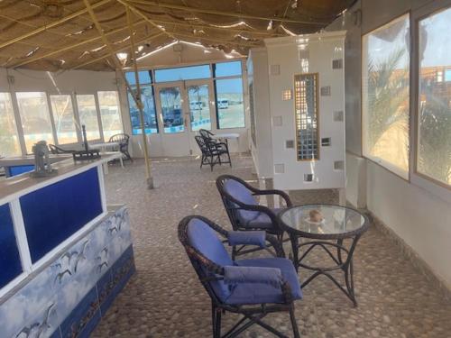 a room with chairs and a table and a counter at Marvel loli camp in Quseir