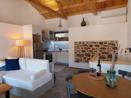 ein Wohnzimmer mit einem weißen Sofa und einem Tisch in der Unterkunft Rock Solid Stone House in Chora in Samothráki