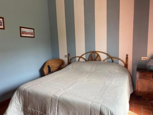 a bedroom with a bed and a striped wall at Al Sangallo Agriturismo in Montecarlo