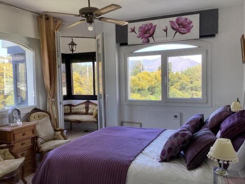 um quarto com uma cama roxa e 2 janelas em Duquesa del Mar Apartmento em Manilva
