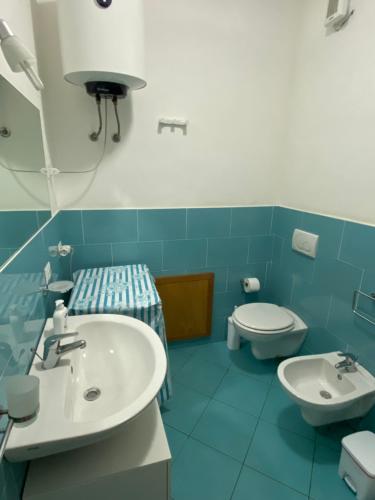 bagno blu con lavandino e servizi igienici di Le Palme House Isola delle Femmine a Isola delle Femmine