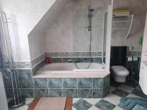 een badkamer met een bad en een toilet bij Logies in Knokke-Heist