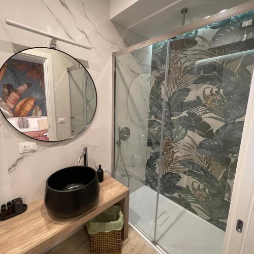 a bathroom with a shower with a sink and a mirror at Namuri Luxury Rooms in Taormina