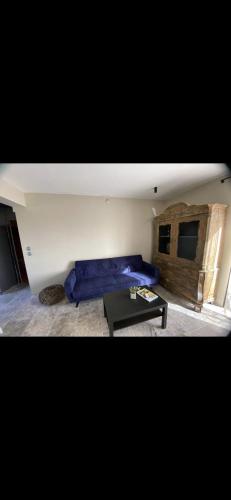 un salon avec un canapé bleu et une table dans l'établissement Appartement T2 au calme, à Toulon