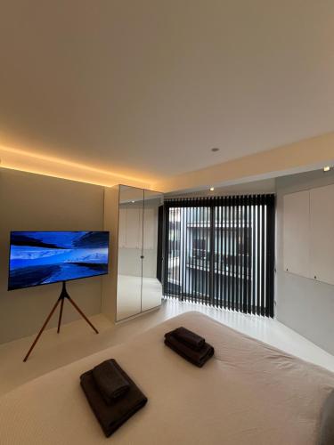 ein Wohnzimmer mit einem Flachbild-TV und einem großen Fenster in der Unterkunft Casa Olmi in Shoreditch in London