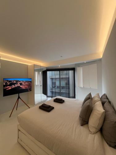 a bedroom with a large bed with a flat screen tv at Casa Olmi in Shoreditch in London