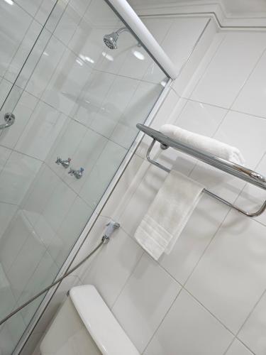 a bathroom with a shower with a glass door at Flat Hotel Slaviero Guarulhos in Guarulhos