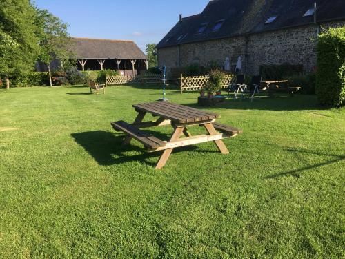 - une table de pique-nique en bois dans la pelouse d'une cour dans l'établissement Les Hirondelles, à Les Portes du Coglais