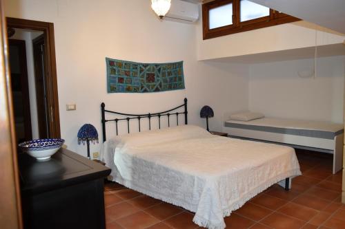 チェファルにあるVilla Marghe -Cefalù-Mazzaforno-Baia dei sette Emiriのベッドルーム1室(ベッド1台、ベンチ付)