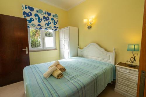 - une chambre avec un lit et une serviette dans l'établissement Casa Branca, à Armação de Pêra