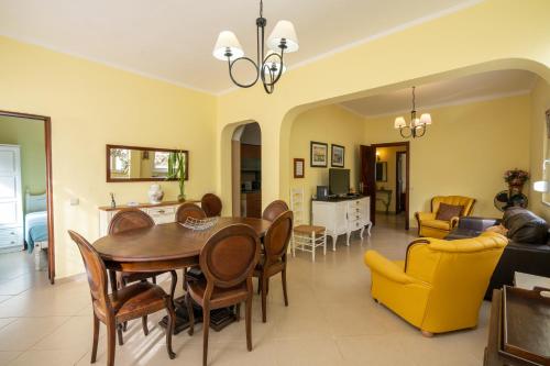 - un salon avec une table et des chaises en bois dans l'établissement Casa Branca, à Armação de Pêra