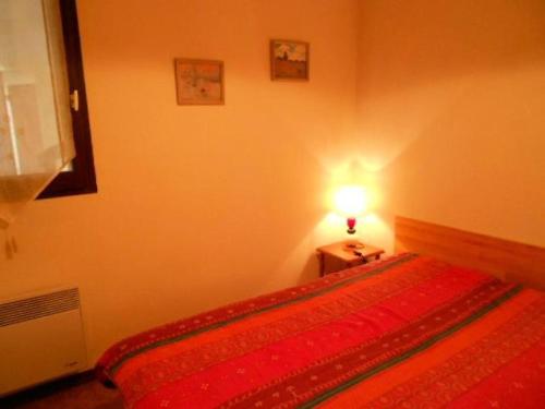 - une chambre avec un lit rouge et une lampe dans l'établissement Résidence Hameau Du - Appartement 4 personnes à 700m du centre MAE-6304, à Vielle-Aure