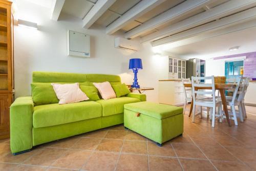 ein grünes Sofa im Wohnzimmer mit einem Tisch in der Unterkunft Midori-an 緑庵 - The Garden in Maglie