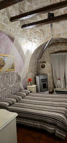 a bedroom with a large bed in a stone wall at La magia del trullo in Martina Franca