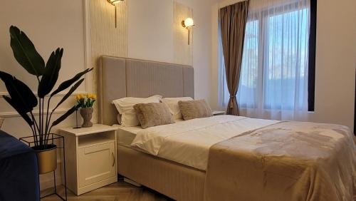 een slaapkamer met een bed met een plant en een raam bij Luxury Mansion in Boekarest