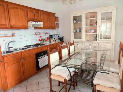 a kitchen with a glass table and some chairs at La Maison des Rèves -Langhe Piemonte in Torre Bormida