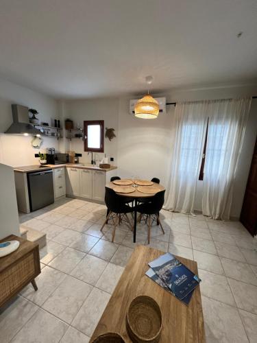 a living room with a table and a kitchen at Olea White in Skiathos Town