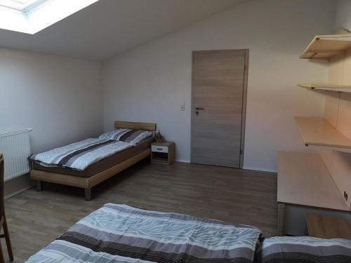 een slaapkamer met 2 bedden en een deur erin bij Ferienhaus-Seedo in Herleshausen