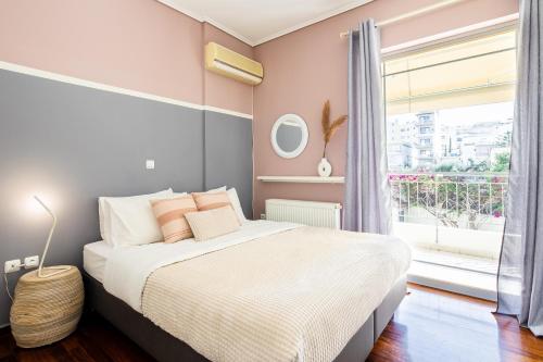 sypialnia z łóżkiem i dużym oknem w obiekcie Dodeka Home w Atenach