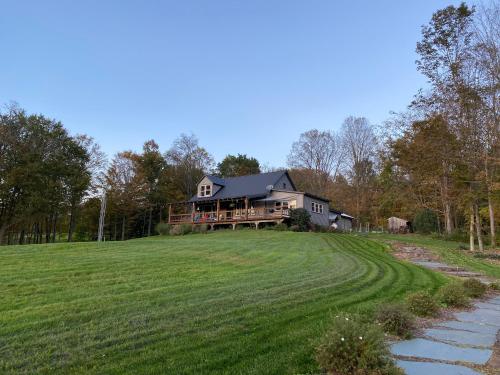 una grande casa in cima a una collina erbosa di Dancing Barefoot Farms a Pawlet