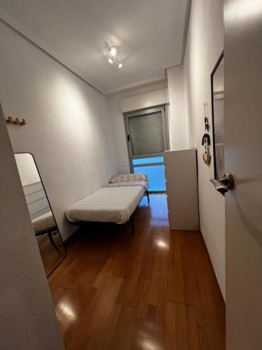 a small room with a bed and a window at Apartamento funcional Arrixaca in El Palmar