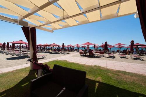 a view of a beach with tables and umbrellas at Casa via Appia Scauri - luminosa, grande a 250 m dal mare e dalla stazione ferroviaria in Scauri