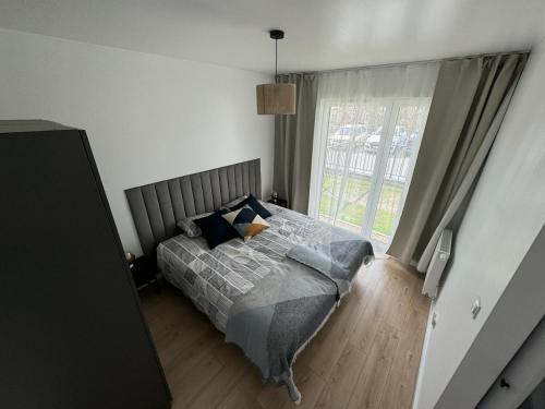 a bedroom with a bed and a large window at Apartament Przystań 2 in Kartuzy