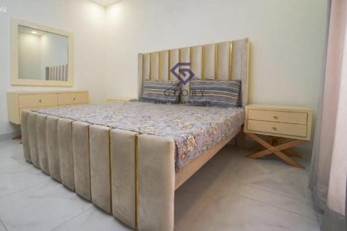 a bedroom with a large bed with a wooden headboard at 1,2 & 3 BHK Luxury Apartments at Zameen Opal in Lahore