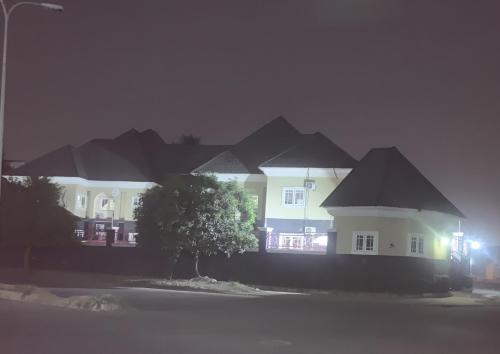 a large white house with black roofs at night at Health Plaza Abuja in Abuja