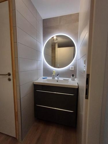 La salle de bains est pourvue d'un lavabo et d'un miroir. dans l'établissement Agréable 3 pièces au Lac Blanc, à Orbey